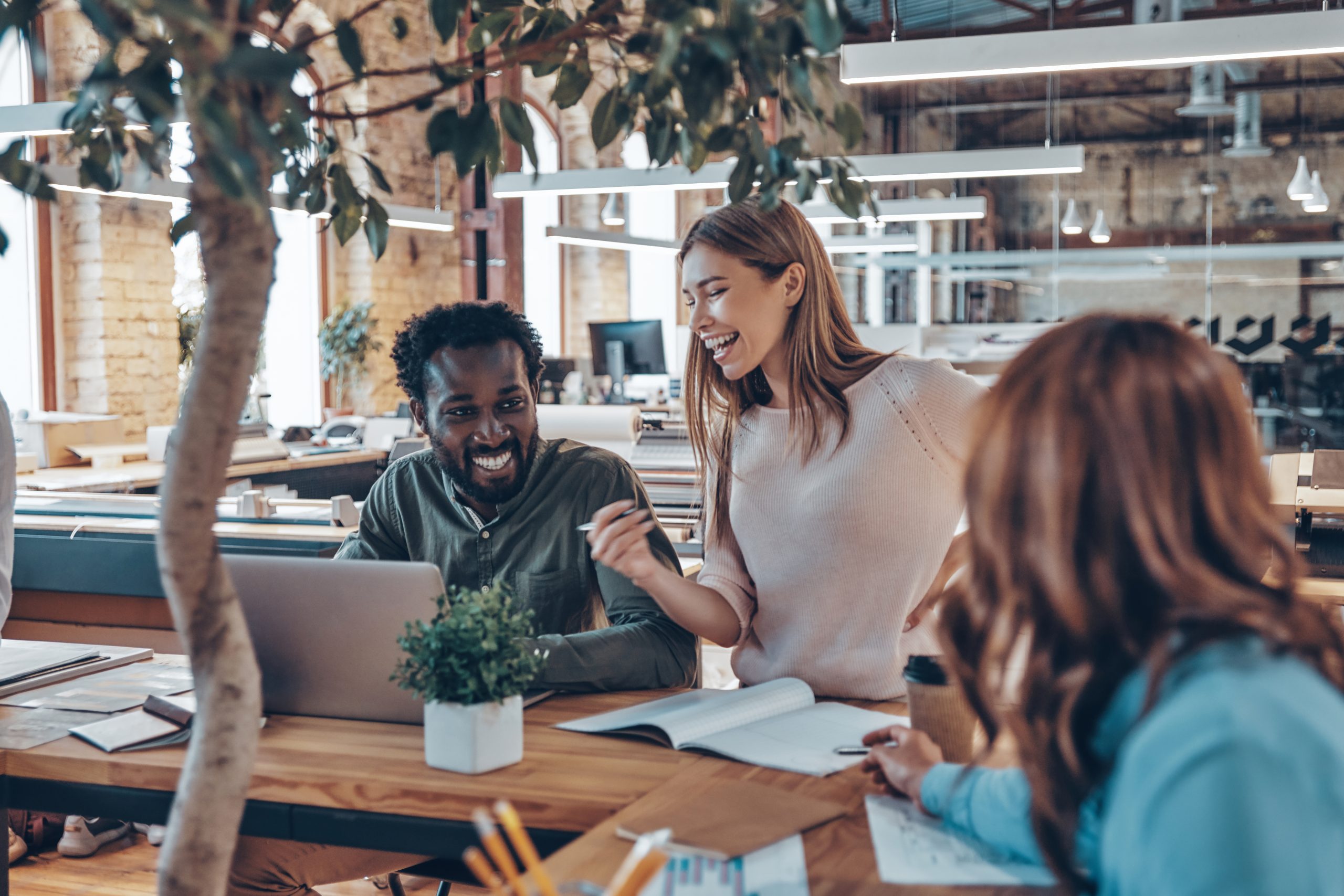 Group of young modern people in smart casual wear talking business ideas while working in the office